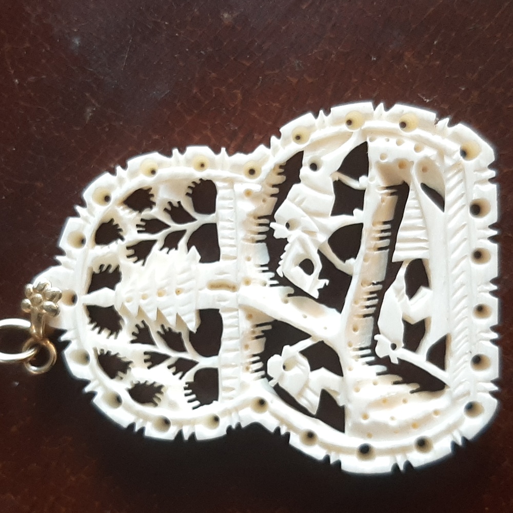 Carved bone? Gilt pendant